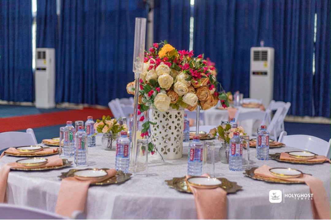 Elegant banquet hall reception with tall floral centerpieces and gold place settings