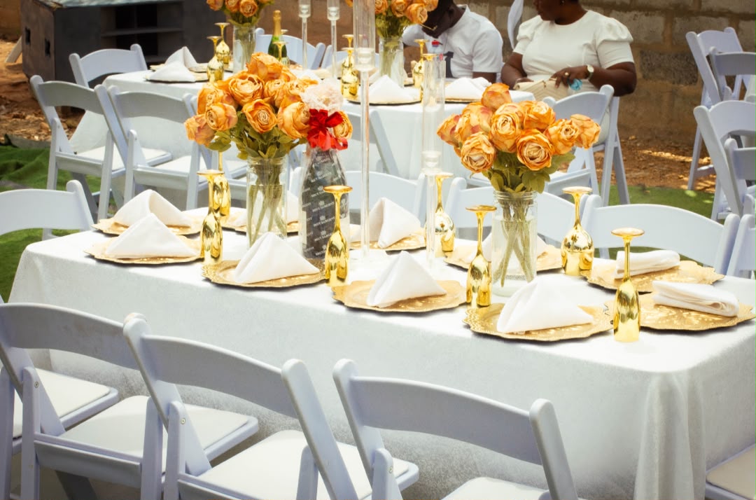 Outdoor reception tablescape with gold roses, white linen and gilded glassware